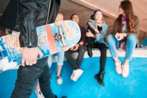 Erschossener junger männlicher Skateboarder trägt Skateboard auf Rampe — Stockfoto