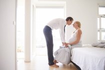 Romantic pregnant couple face to face in bedroom — Stock Photo