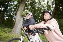 Älteres Ehepaar mit Fahrrad auf Landweg unterwegs — Stockfoto