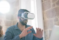 Empresário vestindo fone de ouvido de realidade virtual no escritório — Fotografia de Stock
