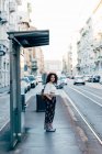 Woman standing at bus stop, Milan, Italy — Stock Photo