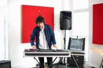 Молодий студент коледжу обертається DJ-вертушки в студії звукозапису — стокове фото