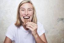Porträt einer Frau, die eine Tafel Schokolade isst — Stockfoto