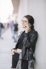 Woman leaning against wall using smartphone — Stock Photo