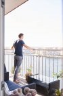 Mann blickt vom Balkon seiner Wohnung auf das Wasser — Stockfoto