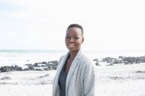 Portrait de jeune femme debout sur la plage — Photo de stock