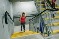 Молода жінка біжить вгору по сходах в приміщенні — стокове фото