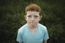 Portrait of red haired boy sticking out tongue — Stock Photo
