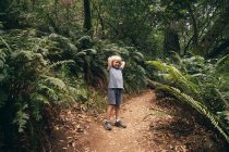 Мальчик в лесу, улыбаясь, смотрит в камеру, Фэрфакс, Калифорния, США, Северная Америка — стоковое фото