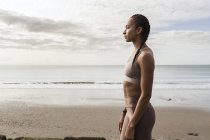 Jovem corredora feminina contemplando a praia — Fotografia de Stock
