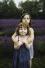 Schwestern blicken in Lavendelfeld in die Kamera — Stockfoto