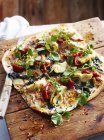 Pancetta, alcachofra e pizza de chicória na placa de serviço, close-up — Fotografia de Stock