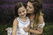 Mutter küsst Tochter im Lavendelfeld — Stockfoto