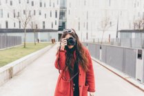 Портрет молодої жінки, що дивиться через видошукач камери — стокове фото