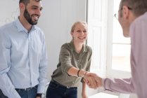 Businesswoman and man shaking hands at boardroom table — Stock Photo