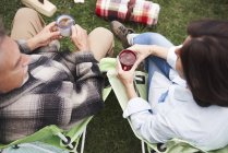 Coppia matura seduta su sedie da campeggio con tazze di tè — Foto stock