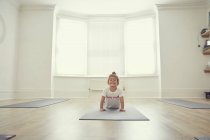 Chica joven en estudio de yoga, en posición de yoga - foto de stock