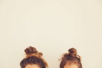 Portrait of mother and daughter, hair in bun, top section — Stock Photo