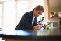 Teenage studentessa doing homework a kitchen counter — Foto stock