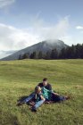 Coppia sdraiata rilassante nel paesaggio campo, Tirolo, Steiermark, Austria, Europa — Foto stock