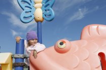 Girl on playground equipment looking away — Stock Photo