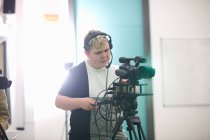 Joven estudiante universitario filmación en estudio de televisión - foto de stock
