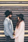 Portrait of young man and woman, face to face, holding hands, pensive expressions — Stock Photo