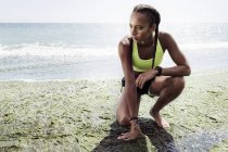 Young woman in sports clothing on beach — Stock Photo
