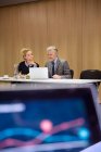 Colegas na sala de conferências tendo reunião, usando laptop — Fotografia de Stock