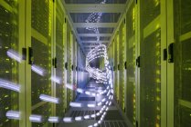 Interior of data centre, lights trails showing travelling data — Stock Photo