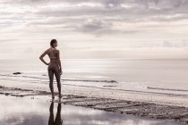 Corredor feminino jovem na praia olhando para o mar — Fotografia de Stock