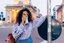 Woman enjoying icy drink in central reservation in street, Milan, Italy — Stock Photo
