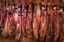Spanish cured ham hanging in Boqueria Market, Barcelona, Catalonia, Spain, Europe — Stock Photo