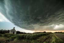 Supercell iminente à distância, igreja abandonada em primeiro plano, Miltonvale, Kansas, EUA — Fotografia de Stock