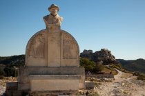 Denkmal von Charloun Rieu und Blick auf entfernte Stadt und Schloss, Les Baux-de-Provence, Provence-Alpes-C? te d 'Azur, Frankreich — Stockfoto