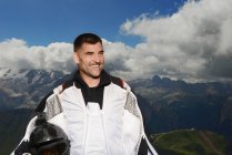 Porträt eines Base Jumper im Wingsuit, der lächelnd wegschaut, Dolomitenberge, Canazei, Trentino-Südtirol, Italien, Europa — Stockfoto