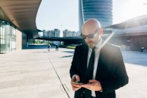 Зрілий бізнесмен використовує смартфон на відкритому повітрі — стокове фото