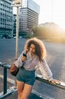 Mulher usando celular contra corrimão de rua, Milão, Itália — Fotografia de Stock