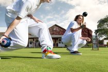 Plan recadré de deux jeunes hommes pelouse bowling sur bowling vert — Photo de stock