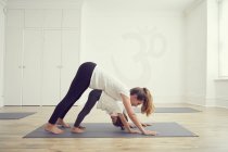Mother and daughter in yoga studio, standing together in yoga position — Stock Photo