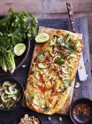 Satay chicken pizza on serving board, elevated view — Stock Photo