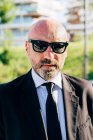 Портрет взрослого бизнесмена в солнечных очках на открытом воздухе — стоковое фото