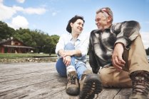 Couples d'âge mûr se souriant sur une jetée en bois — Photo de stock