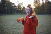 Молода жінка тримає гарбузи в сільській місцевості — стокове фото