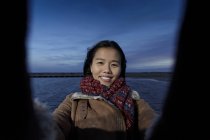Portrait de jeune femme prenant selfie sur la plage au crépuscule — Photo de stock