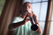 Close up of girl playing on clarinet indoor — Stock Photo