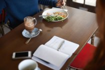 Abgeschnittene Ansicht von Kunden beim Essen im Café — Stockfoto