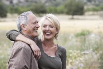 Couple in field smiling — Stock Photo