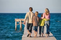 Rear view of family walking on pier — Stock Photo