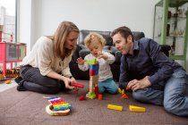 Батьки і дитина хлопчик грають з будівельними блоками — стокове фото